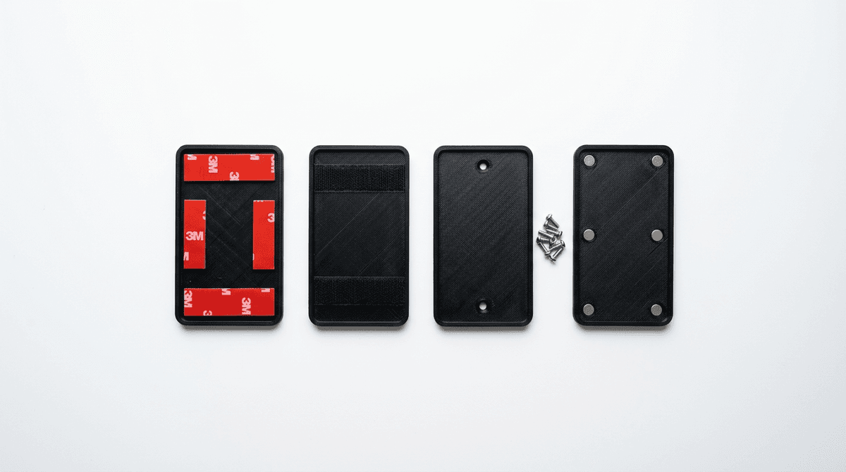 A 3D-printed custom number plate with all four fixing options laid out: adhesive pads, velcro strips, stainless steel screws, and neodymium magnets